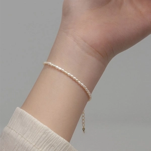 Elegant freshwater pearl bracelet with adjustable gold chain on woman's wrist