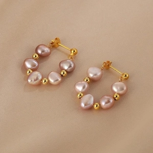 Baroque irregular pink pearl stud earrings with gold accents on soft pink silk background
