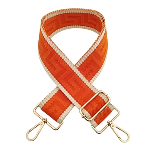 Detail of adjustable 5cm wide orange and beige woven shoulder strap with gold metal buckles