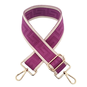 Detail of purple wide adjustable shoulder strap with gold metal buckle and maze pattern