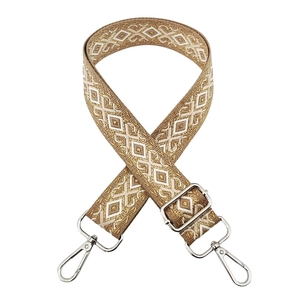 Close-up of beige and gold diamond patterned embroidery with silver metal hardware