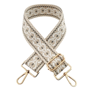 Detail of 5cm wide beige jacquard embroidered strap with grey geometric patterns and gold clips