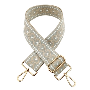 Close-up of 5cm wide jacquard bag strap in beige and gray with gold metal hardware