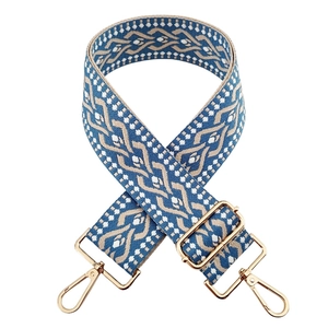 Detail of blue and beige geometric woven bag strap with golden metal spring hooks
