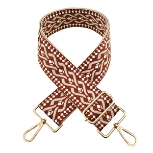 Close-up of 5cm wide brown and beige geometric jacquard strap with gold metal hooks