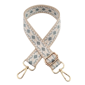Close-up of geometric jacquard bag strap with gold metal hooks and adjustable buckle