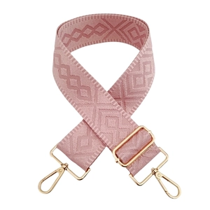 Detailed view of pink geometric diamond pattern bag strap with gold metal swivel hooks
