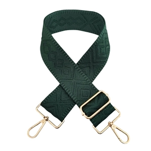 Close-up of dark green embroidered geometric diamond strap with gold metal hooks