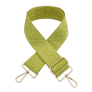 Detail of avocado green geometric woven bag strap with adjustable gold hardware