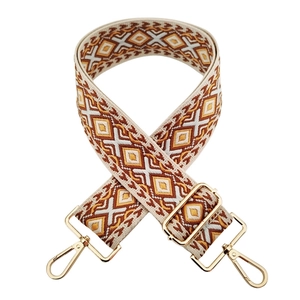 Detail of 5cm wide colorful geometric jacquard bag strap with gold metal hooks and buckle