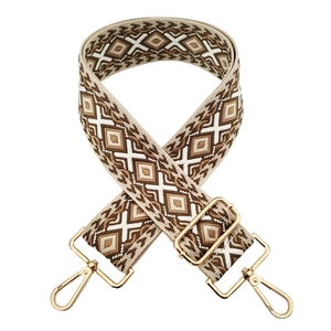 Detail of a 5cm wide beige and brown geometric jacquard strap with gold metal buckles