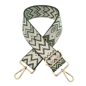 Detail of adjustable jacquard bag strap with green wave pattern and gold metal hooks