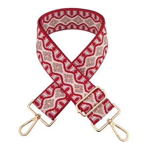 Detail of red and beige jacquard wide bag strap with gold-tone swivel hooks