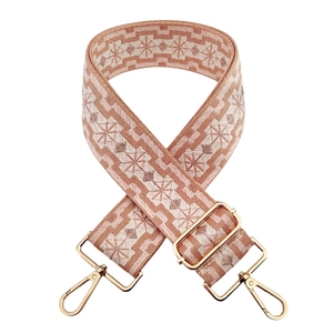 Detail of pink geometric jacquard strap with polished gold-tone metal snap hooks