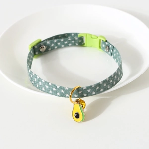 Detail of green star-patterned pet collar with avocado pendant and golden bell