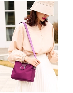 Detail of purple nylon crossbody bag with wide shoulder strap and silver ring buckle
