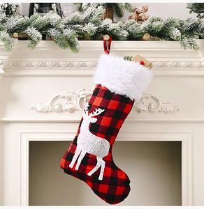 Détail de la chaussette de Noël à carreaux rouges et noirs avec renne blanc et fausse fourrure