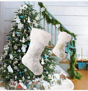 Detail of white velvet Christmas stockings with silver snowflake embroidery and faux fur trim