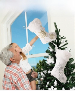 Family hanging white plush Christmas stockings with gold and silver snowflake embroidery
