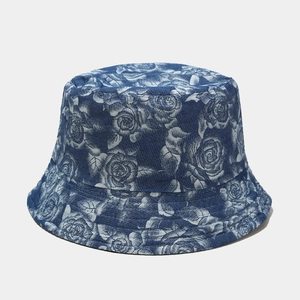 Detailed view of floral bucket hat with white roses on navy blue denim fabric