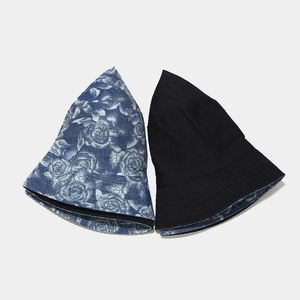 Detail of reversible bucket hat showing blue floral print and black solid cotton sides