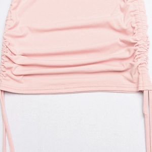 Detailed close-up of pink knit dress hem featuring adjustable drawstring ruching detail