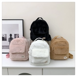 Primer plano de mochilas de felpa en rosa, blanco, marrón y negro sobre una base blanca