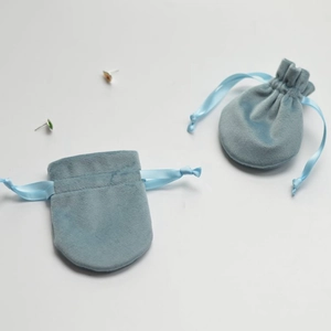 Detailed view of light blue velvet drawstring jewelry pouches with soft fabric texture