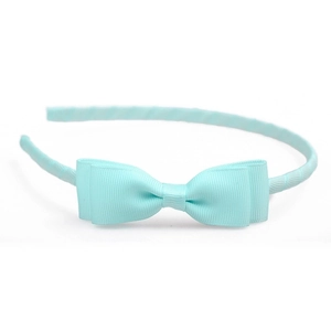 Detail of mint green grosgrain ribbon texture and layered bow on a slim headband