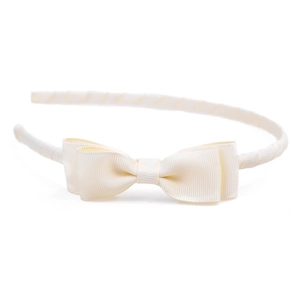 Detailed view of cream grosgrain ribbon headband featuring a double-layered bow ornament