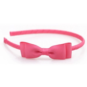Detail of bright pink grosgrain ribbon texture on a layered bow headband for girls