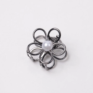 Detailed view of the dark grey metal flower hair claw clip with a white pearl center