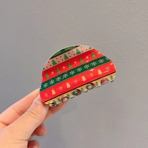 Detail of Christmas hair clips featuring colorful trees, snowflakes and golden bells