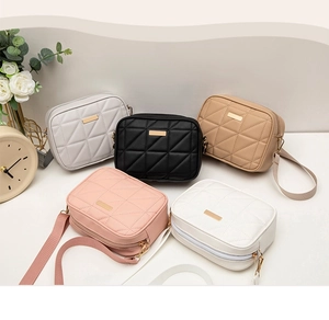 Detailed overhead shot of diamond-quilted PU leather bags with wide woven shoulder straps