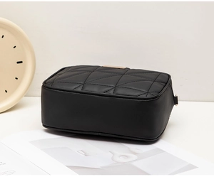 Close-up of black quilted PU leather crossbody bag featuring gold zipper and D-ring detail