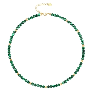 Detail of beaded necklace featuring green malachite stones and golden heart pendant