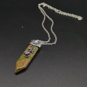 Macro shot of Unakite hexagonal prism pendant with vintage silver engraving and amethyst