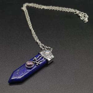 Detail of lapis lazuli hexagonal pendant with ornate silver metal and gemstones