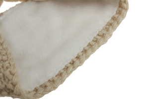 Detailed macro view of soft white faux fur lining and light brown knit headband