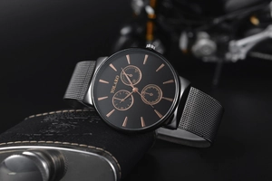 Detail of Yolako men's business watch with black dial and mesh strap on a leather flask