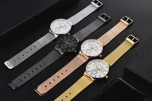 Detailed view of four stylish mesh strap men's watches in silver, grey, gold, and rose gold