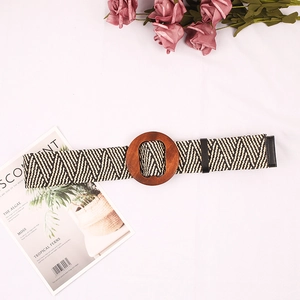 Close-up of woven belt with wooden round buckle and black and white herringbone pattern