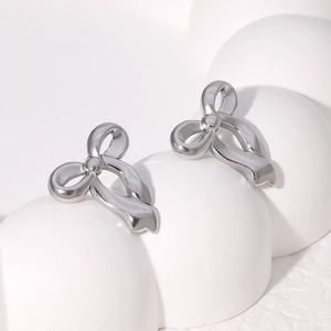 Elegant silver bow stud earrings in 18K gold plated stainless steel on a white base