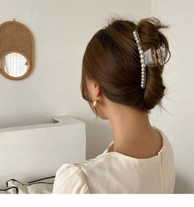 Detailed view of long translucent hair claw clip with elegant white pearl embellishments