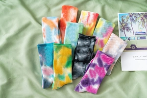 Close-up of ribbed tie-dye crew socks in vibrant blue, pink, and yellow cotton blend