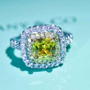 Macro shot of yellow cushion cut gemstone ring with double halo pavé diamonds