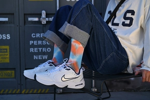 Close-up of blue and orange tie-dye cotton mid-calf socks in a street style setting