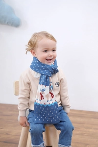 Détail de l'écharpe tricotée pour enfants avec motifs festifs de rennes et flocons