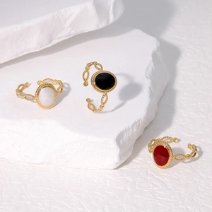Detailed view of vintage gold-plated rings with black, white, and red oval gemstone faces