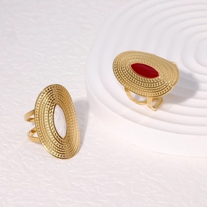 Close-up of vintage wide 18K gold-plated rings with red and white enamel insets